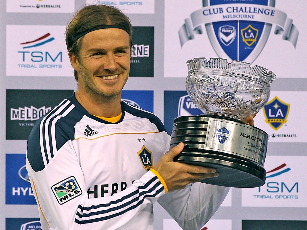 David Beckham holds the man of the match trophy after LA Galaxy won the Hyundai Club Challenge in Melbourne yesterday