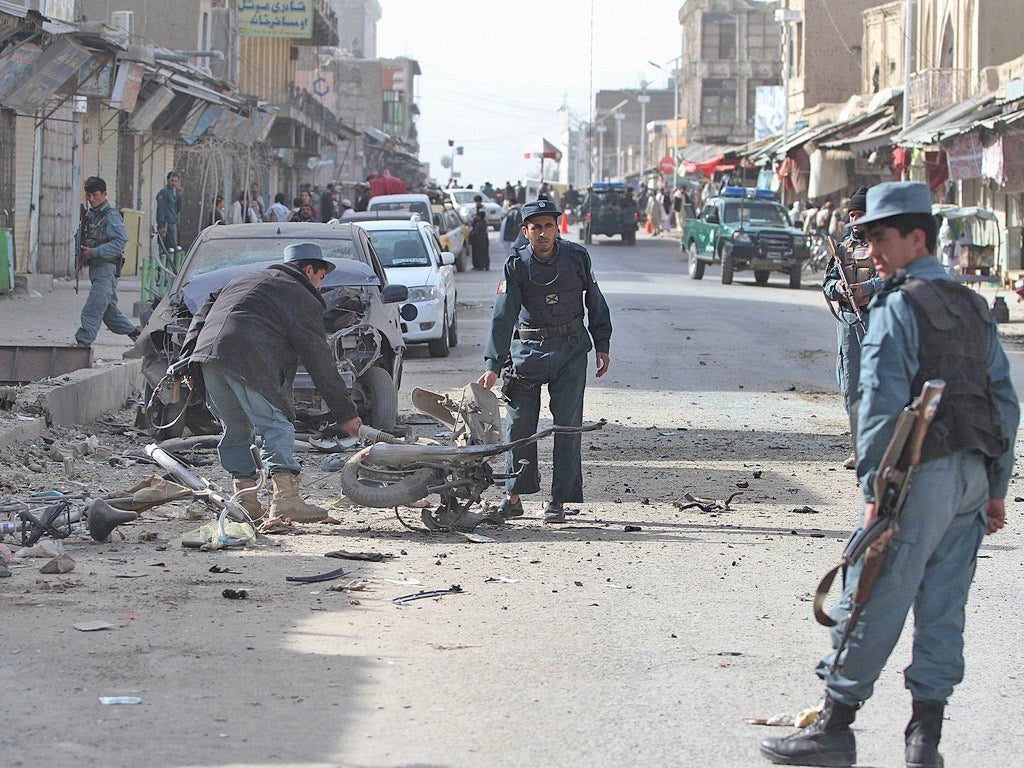 Afghan policemen inspect the scene