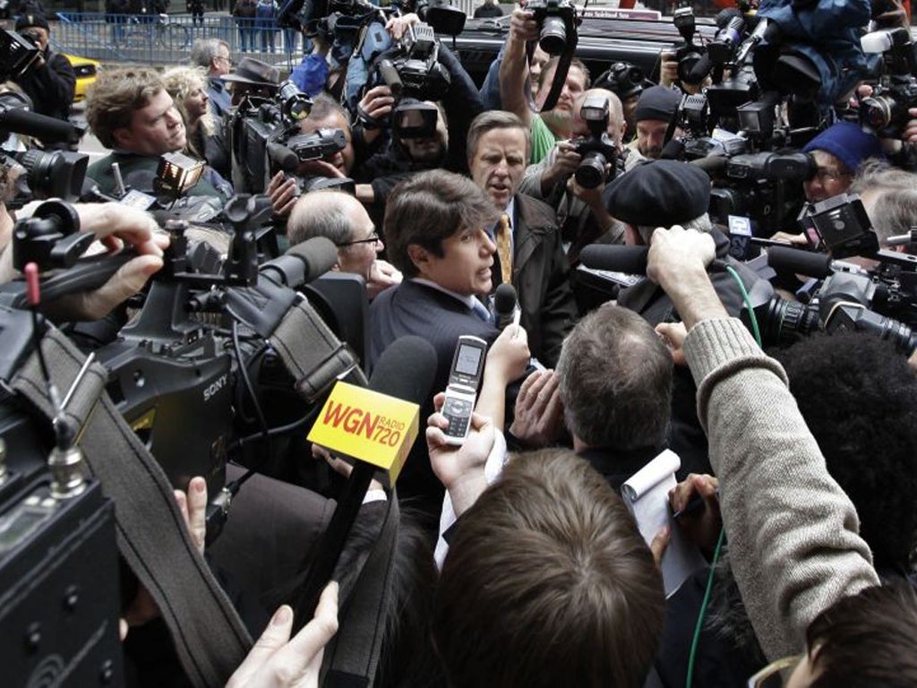 Rod Blagojevich, centre, fights his way through the media scrum as he leaves the federal court in Chicago