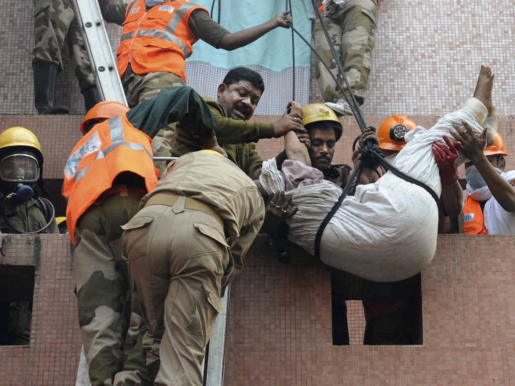 Rescue workers use ropes to evacuate patients and staff from the fire