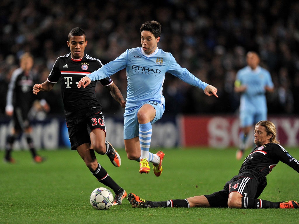 Samir Nasri vaults over Bayern Munich's Anatoliy Tymoshchuk