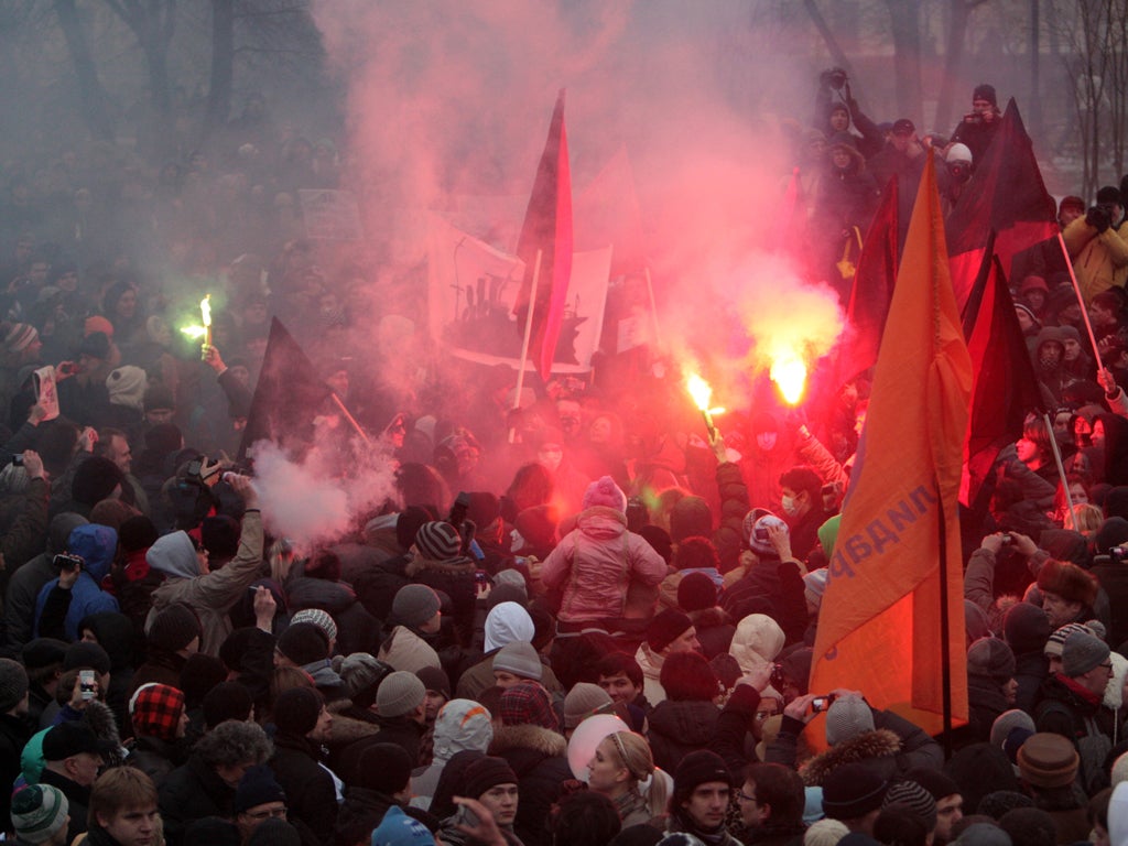 Demonstrators light flares during a mass rally in Moscow yesterday, as tens of thousands gathered to protest against alleged vote rigging in Russia's parliamentary elections