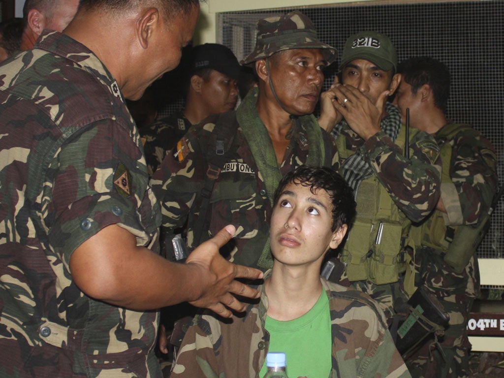 Kevin Lunsmann, 14, with Filipino soldiers inZamboanga’s military compound after his ordeal