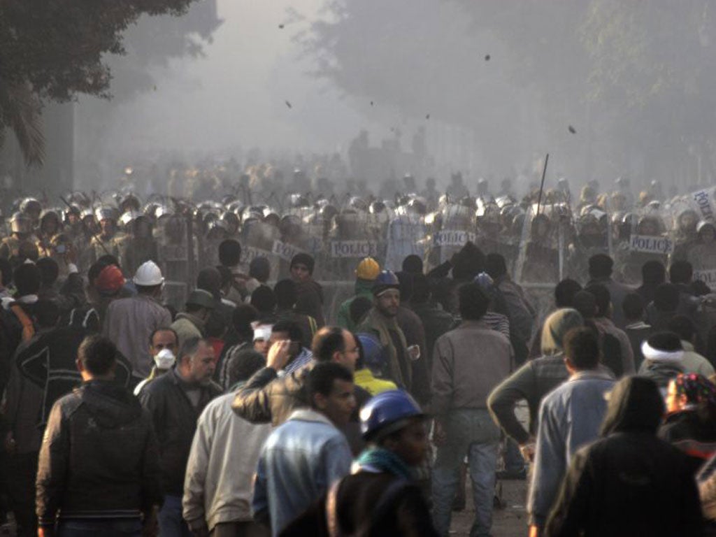 <p>Egyptian protesters throw stones toward military police during clashes near Tahrir Square in Cairo</p>