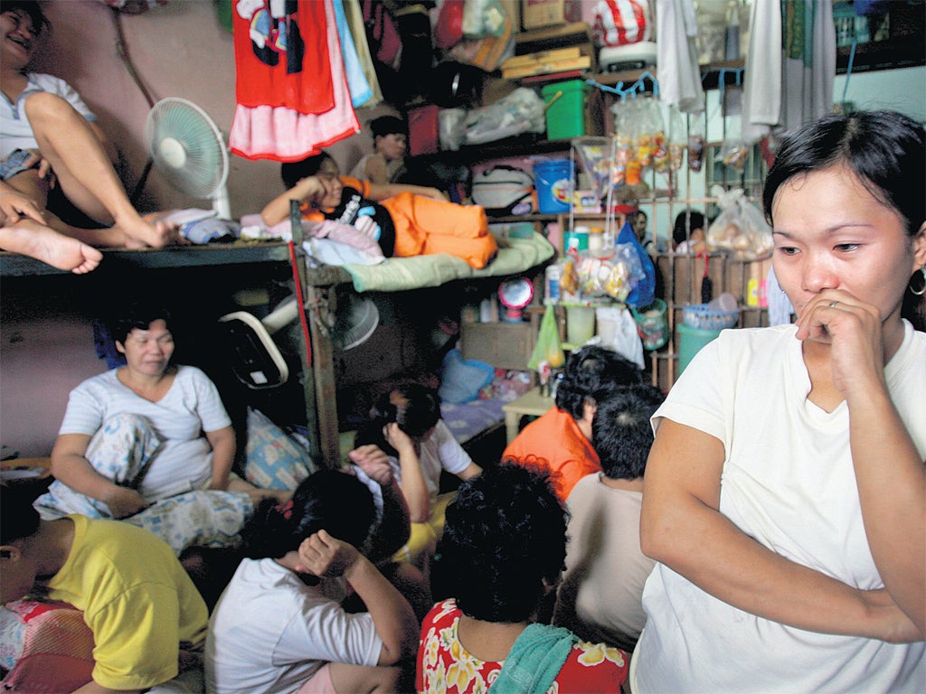 <p>Overcrowded and insanitary: A woman stands in the corner of a female cell, where several dozen inmates are crammed in, at the Navotas Municipal Prison in Manila, Philippines</p>