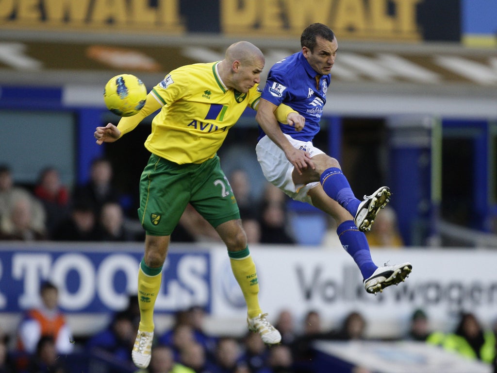 Everton scorer Leon Osman (right) jumps for the ball with Norwich's Marc Tierney