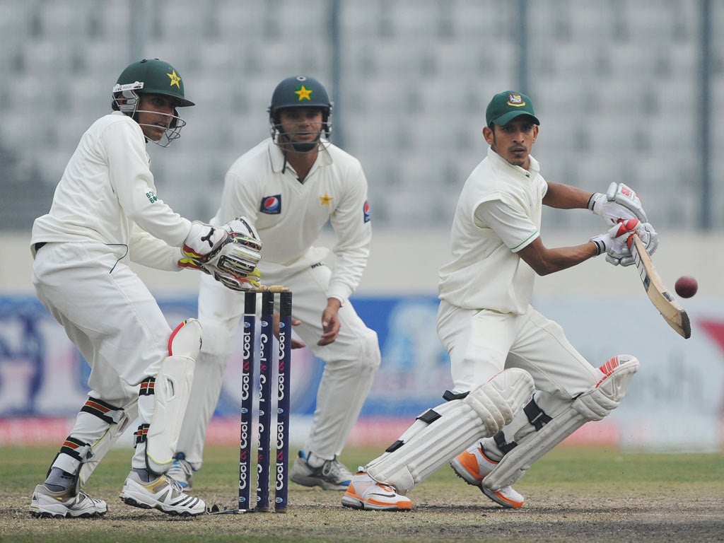 Bangladeshi batsman Nasir Hossain (R) plays a shot as the Pakistan's wicketkeeper Adnan Akmal (L) and Azhar Ali (C) look on