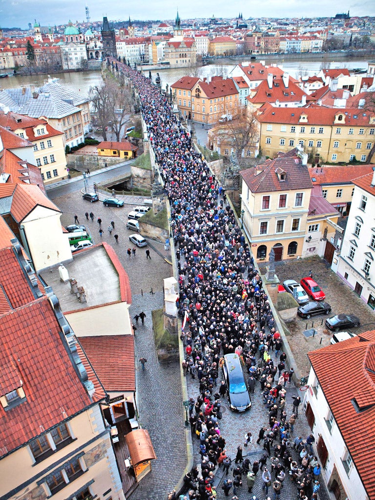 A procession of mourners crosses the Charles Bridge in Prague