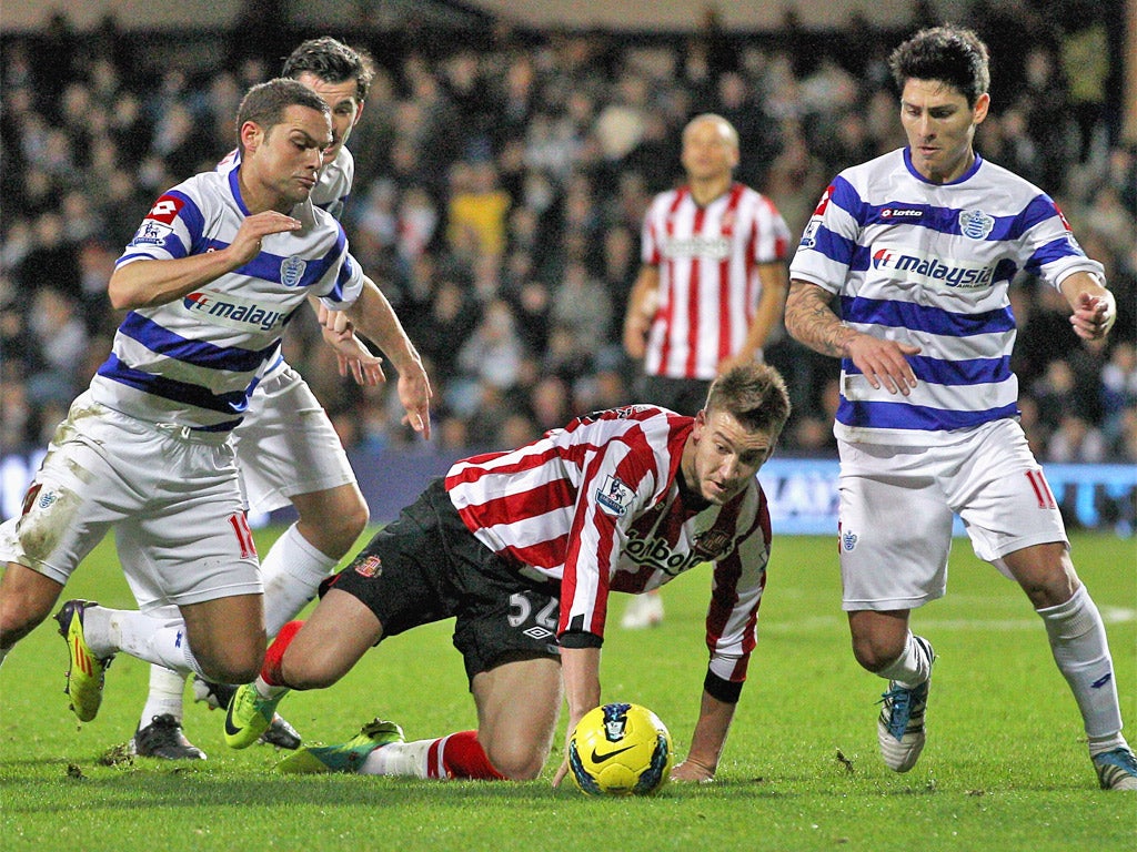 Sunderland's Nicklas Bendtner fights for the ball with Luke Young (left) and Alejandro Faurlin, of QPR