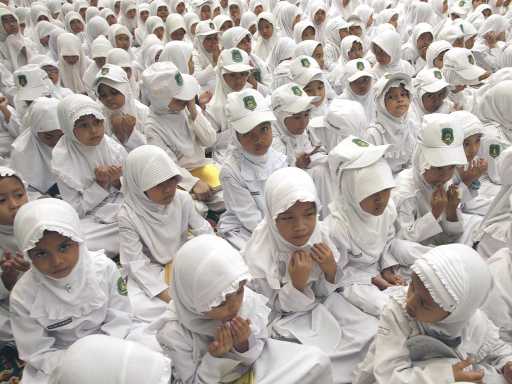 Children pray for those who died in the Boxing Day 2004 tsunami