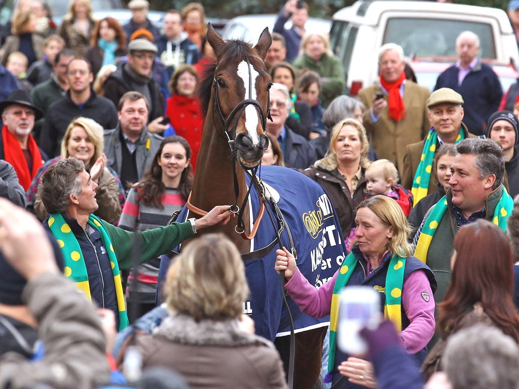 Trainer Paul Nicholls (far right) looks on as head lad Clifford Baker and groom Rose Loxton parade King George VI Chase
winner Kauto Star around his home village of Ditcheat yesterday