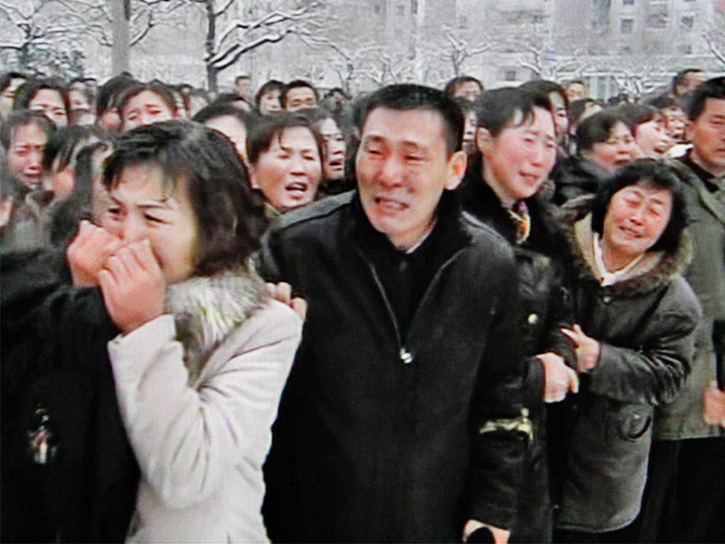 Mourners weep along the procession route