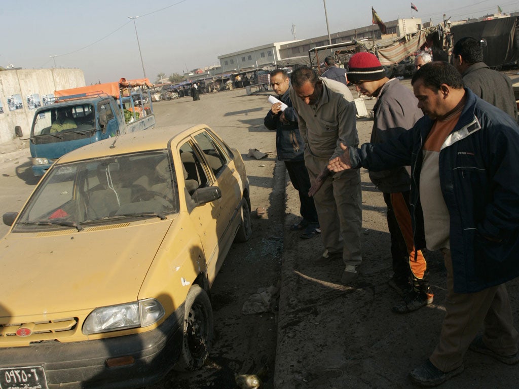 People gather at the site of one of the bomb attacks in Sadr city