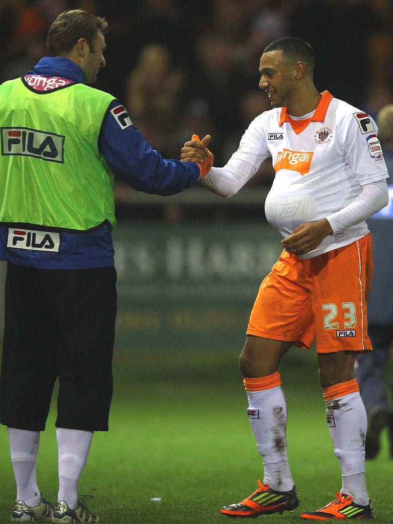 Blackpool striker Matt Phillips walks off with the
match ball under his shirt after scoring a hat-trick
against Fleetwood