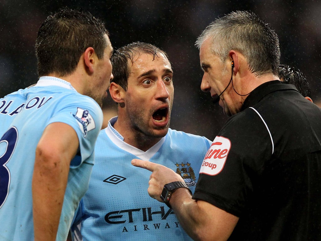 Aleksandar Kolarov and Pablo Zabaleta disagree with referee Chris Foy yesterday