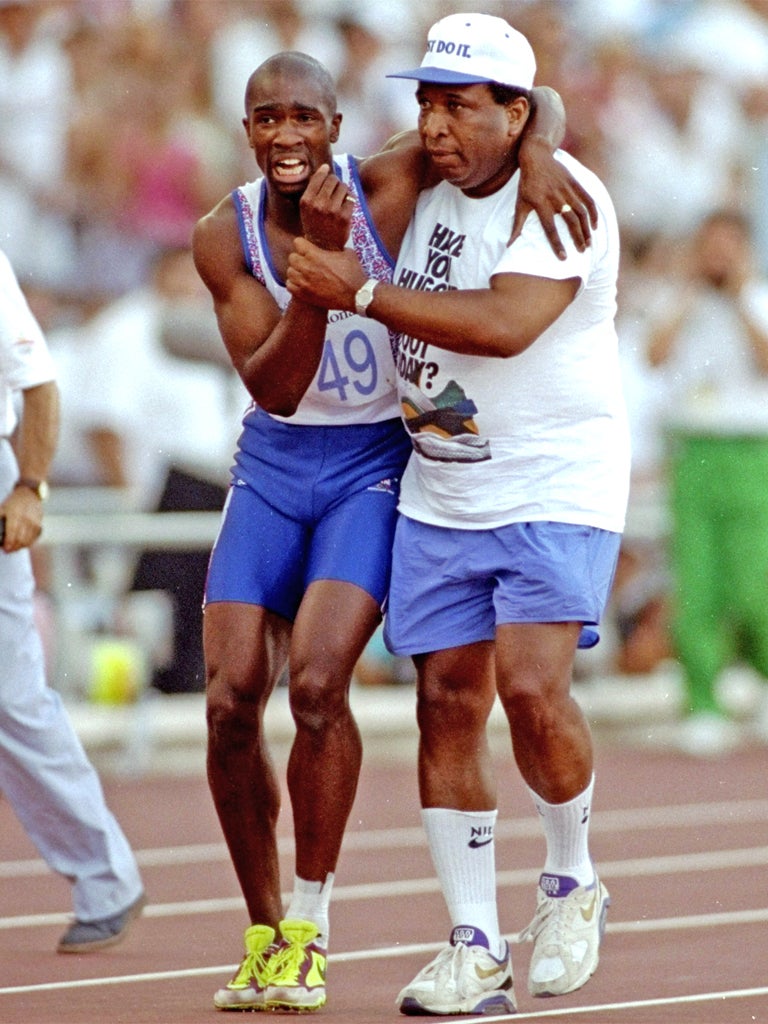 Jim Redmond helps his injured son Derek cross the line in the 400m semi-final at the Barcelona Olympics in 1992