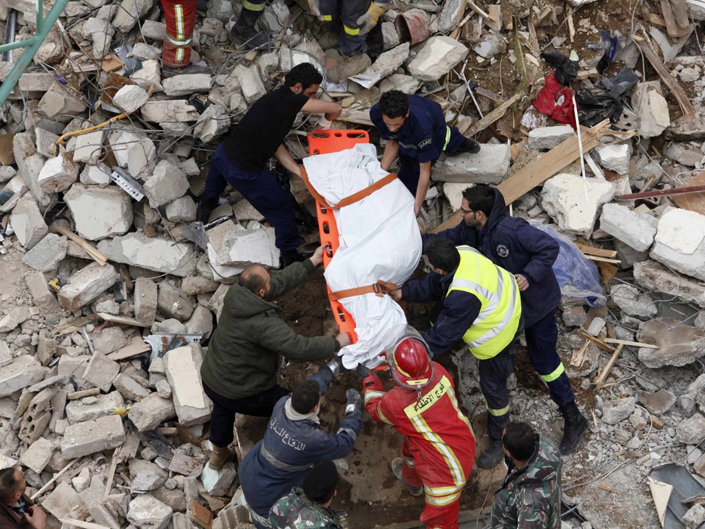 A dead body is pulled from the rubble of the collapsed building
yesterday
