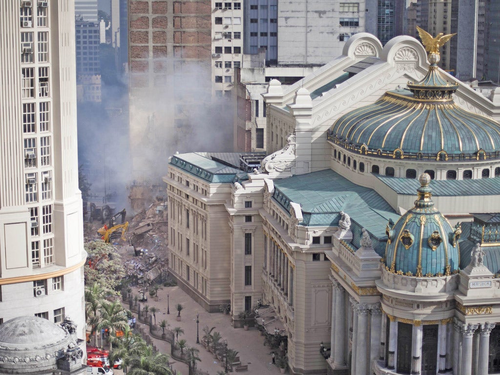 Rescue workers search for victims after a building collapsed near the Municipal Theater in Rio de Janeiro