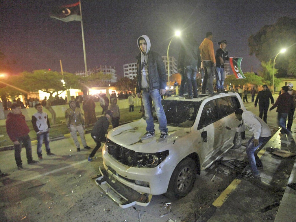 Libyans damage the car of National Transitional Council (NTC) chairman Mustafa Abdel Jalil, to express their dissatisfaction