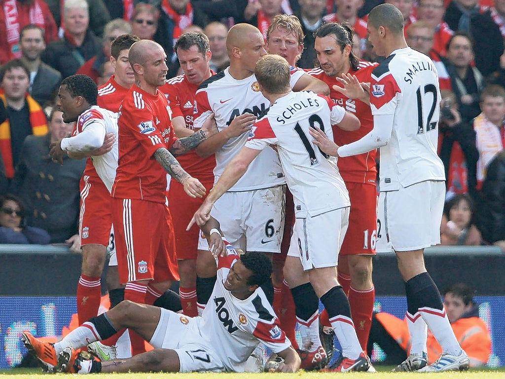 Paul Scholes is surrounded by Liverpool players during last March’s League game at Anfield