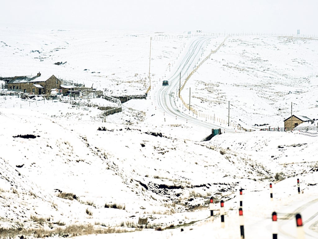 A car struggles up a snow-covered hill in Killhope, County Durham