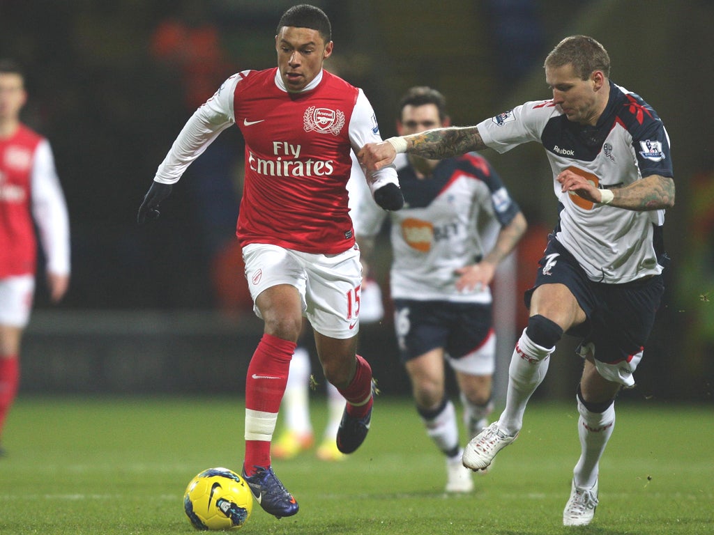 Alex Oxlade-Chamberlain tries to outrun Bolton’s Gretar Steinsson