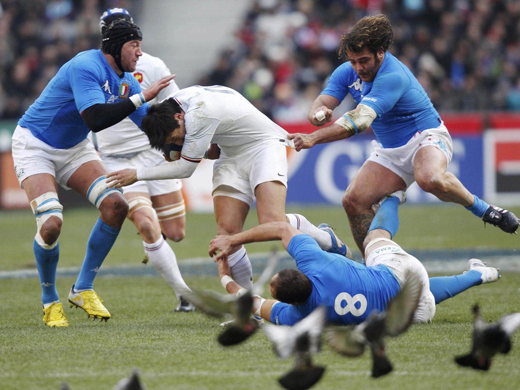 Le crunch: France’s François Trinh-Duc is tackled by Sergio Parisse, Cornelius van Zyl and Andrea lo Cicero in Paris