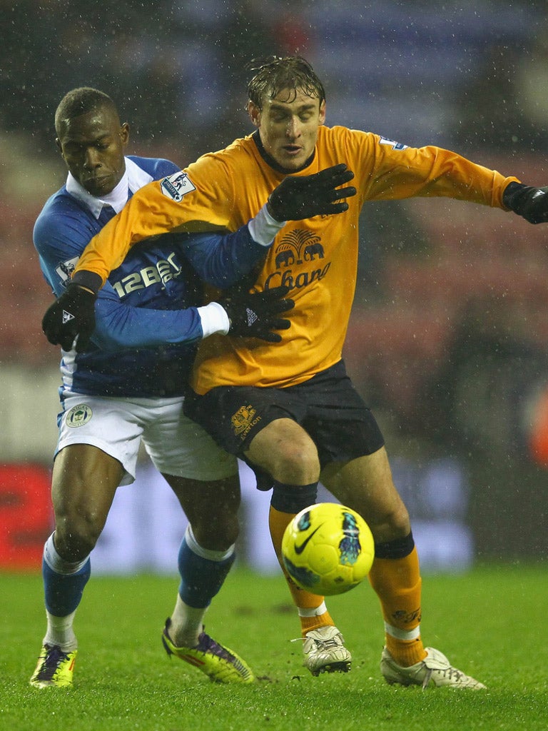 Holding man: Wigan’s Maynor Figueroa (left) challenges Nikica Jelavic