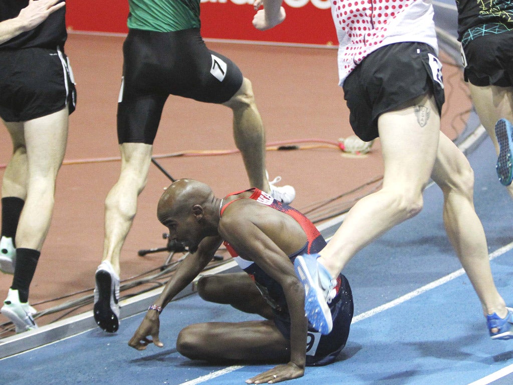 The pack runs around Mo Farah after he fell in the mile at Boston