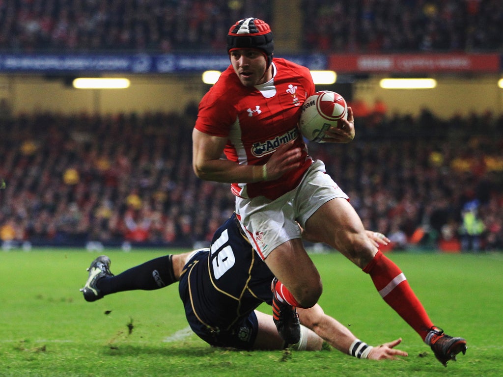 Leigh Halfpenny of Wales breaks past John Barclay of Scotland to goes over to score his second try