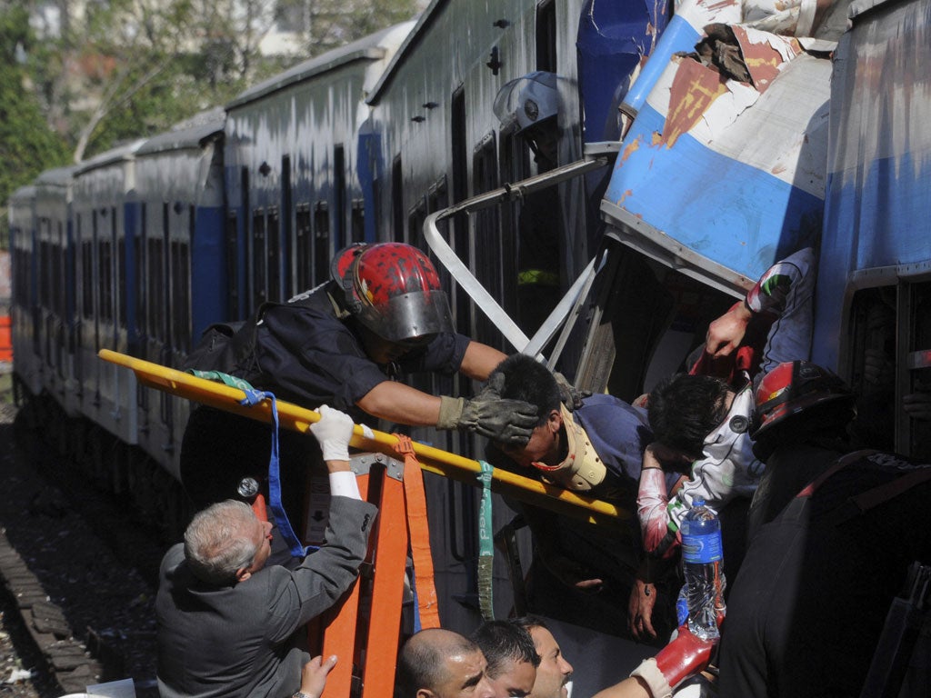 Firemen rescue wounded passengers from a commuter train after a collision in Buenos Aires