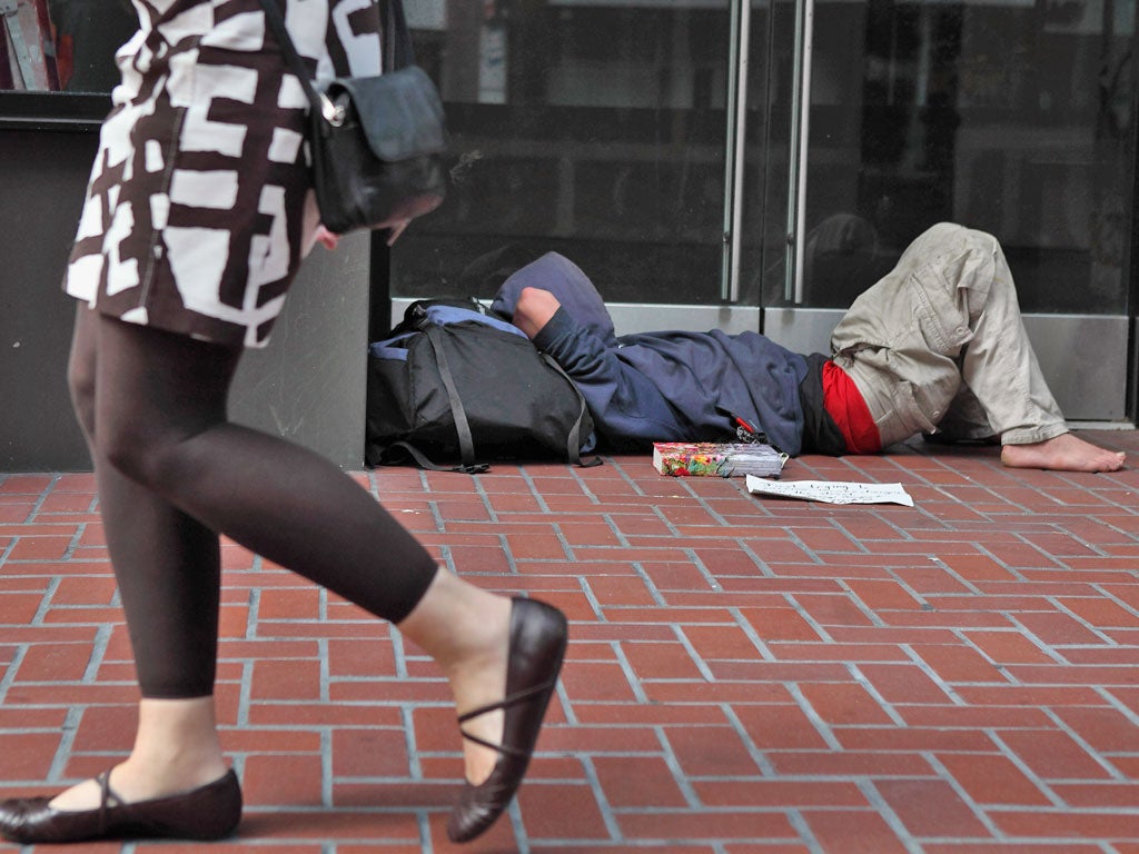 A homeless man sleeps in the street