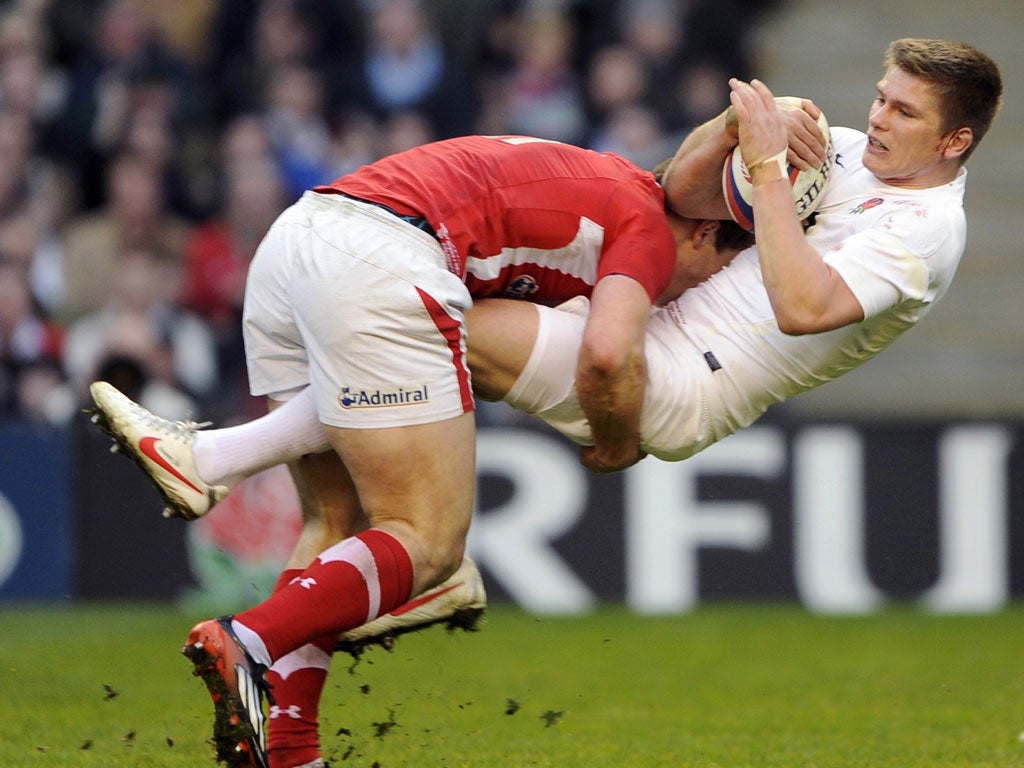 Owen Farrell is tackled by Wales' George North