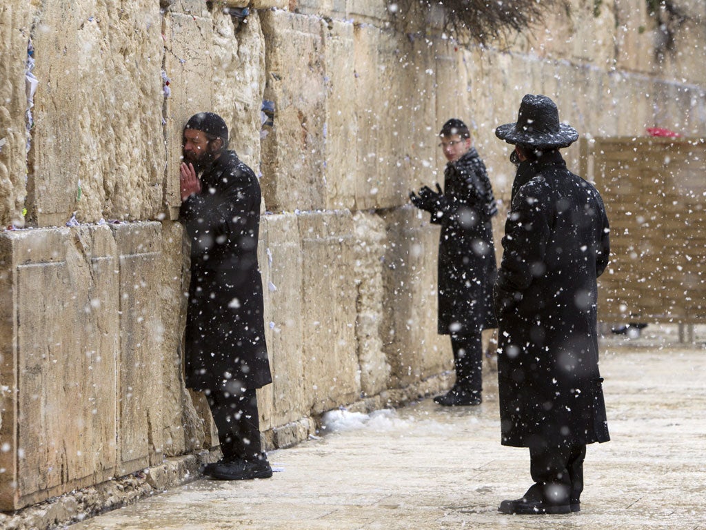 Men at the Wailing Wall during the snow fall