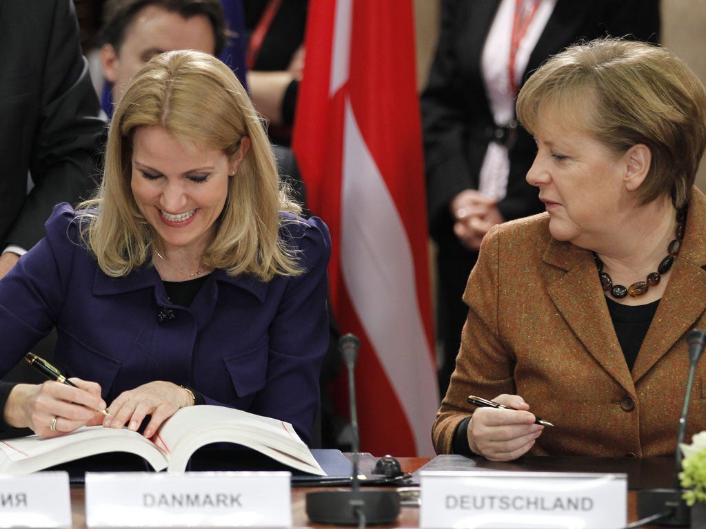 Angela Merkel (right) and Danish Prime Minister Helle Thorning Schmidt sign the EU fiscal compact in Brussels yesterday