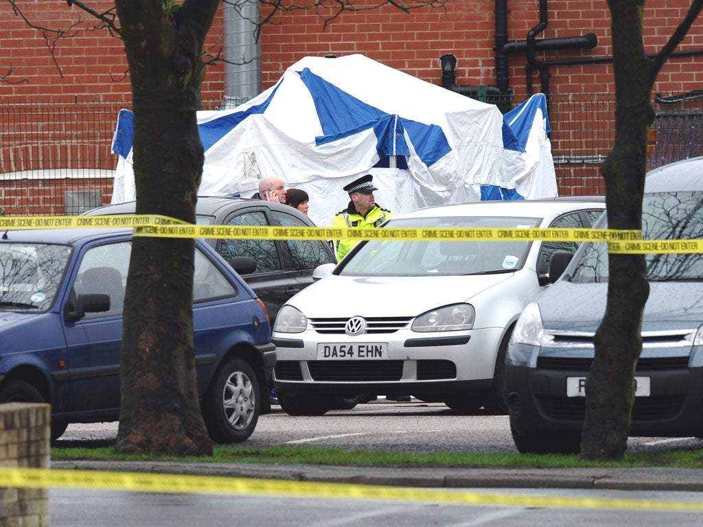 A police officer stands near the scene of the shooting