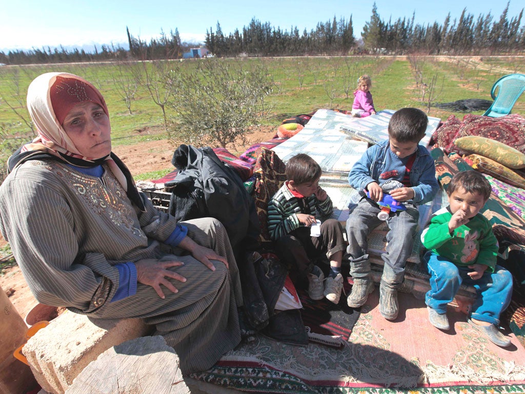 Syrian refugee Hassana Abu Firas with her family at the Lebanese-
Syrian border village of Qaa. Up to 2,000 Syrians have poured across the border in the past two days