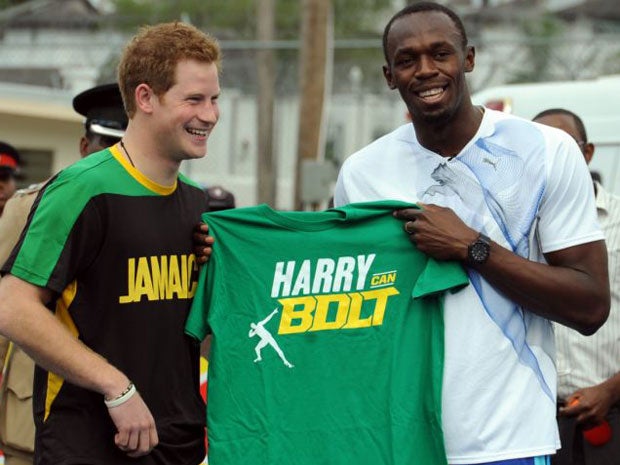 Prince Harry receives a T-shirt as a gift from Olympic sprint champion Usain Bolt