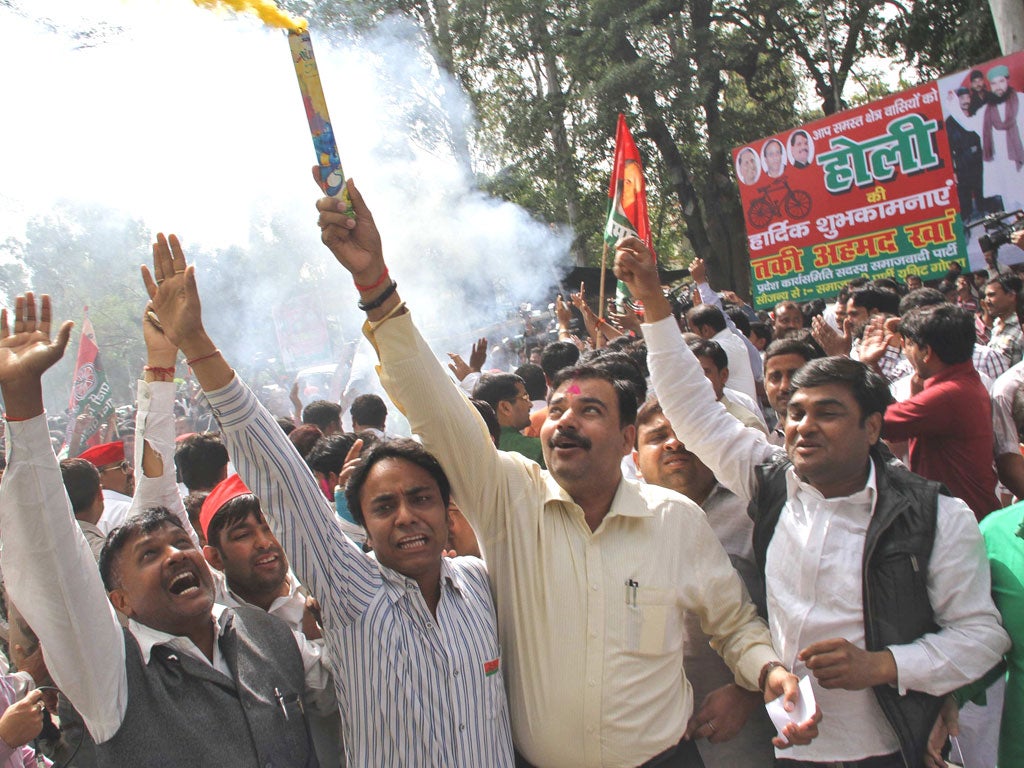 Supporters of Samajwadi Party celebrate as they looked set to win the most seats in Uttar Pradesh