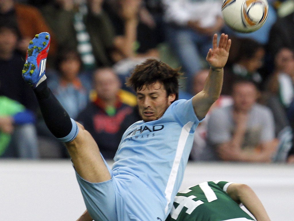 Manchester City's David Silva tussles with Sporting Lisbon's Joao Pereira last night