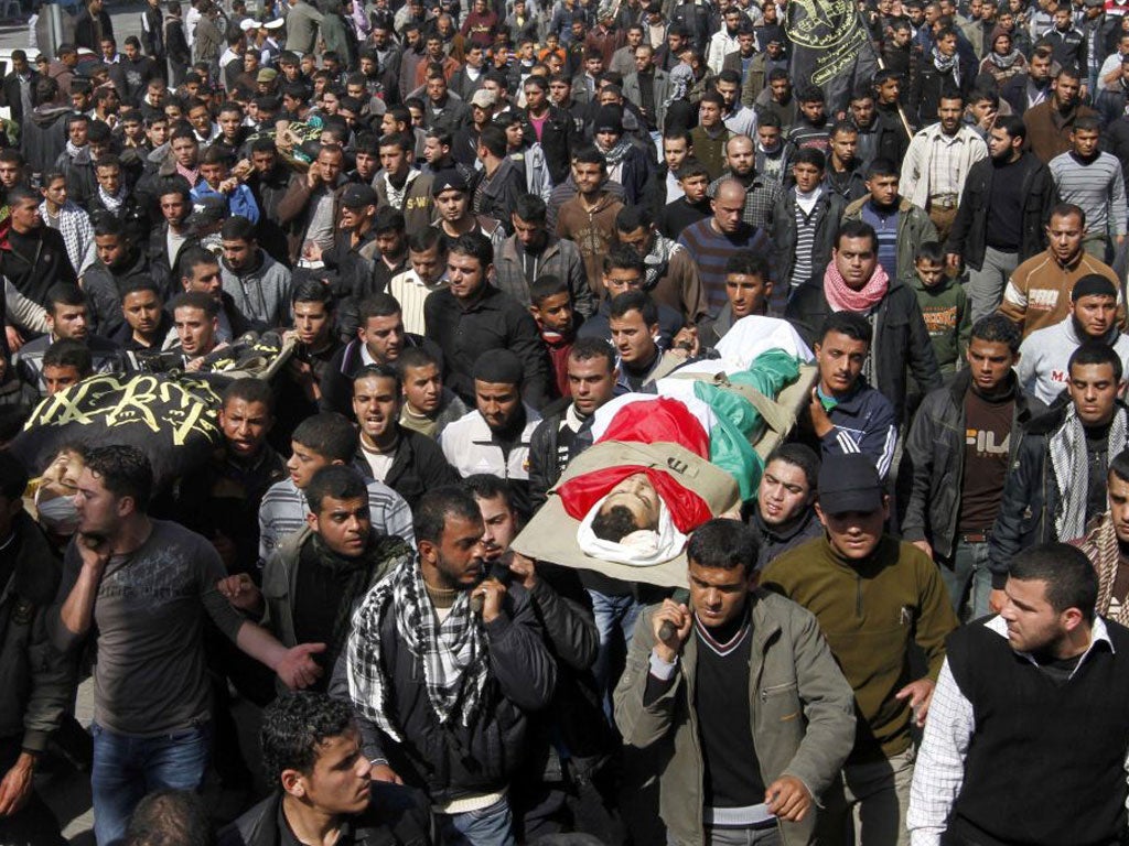 Palestinian mourners carry the bodies of seven Islamic Jihad militants, who were killed in Israeli air strikes