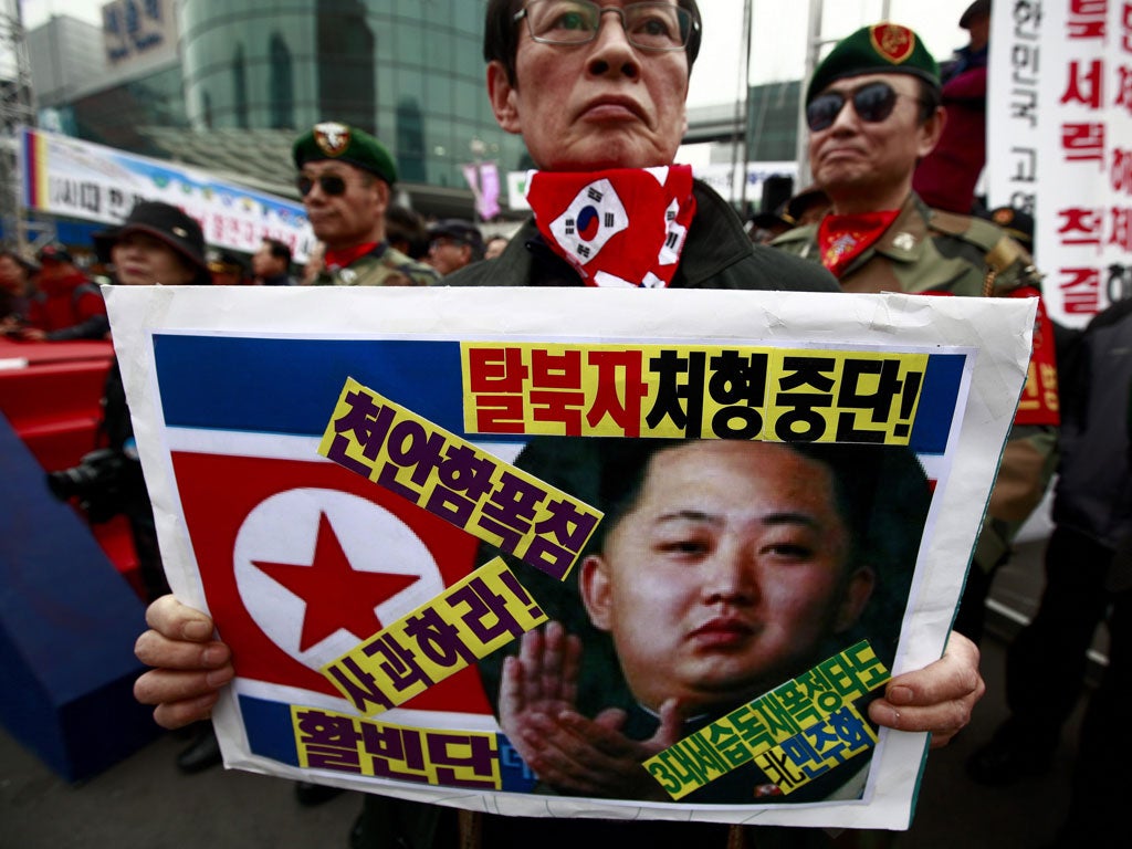 A South Korean war veteran holds a picture of the North’s new leader Kim Jong-Un at a protest in Seoul yesterday