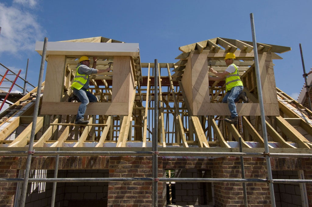 Construction boost: Builders working on windows on the roof of a new house