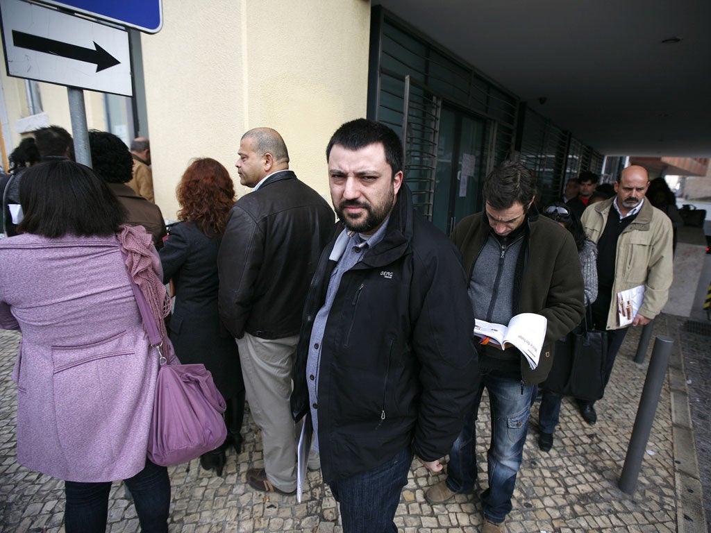 Hunting for employment: José Guedes, centre, 35, queues at the Angolan consulate in Lisbon, last month, to request a visa. He thinks his engineering skills will be in demand in Africa