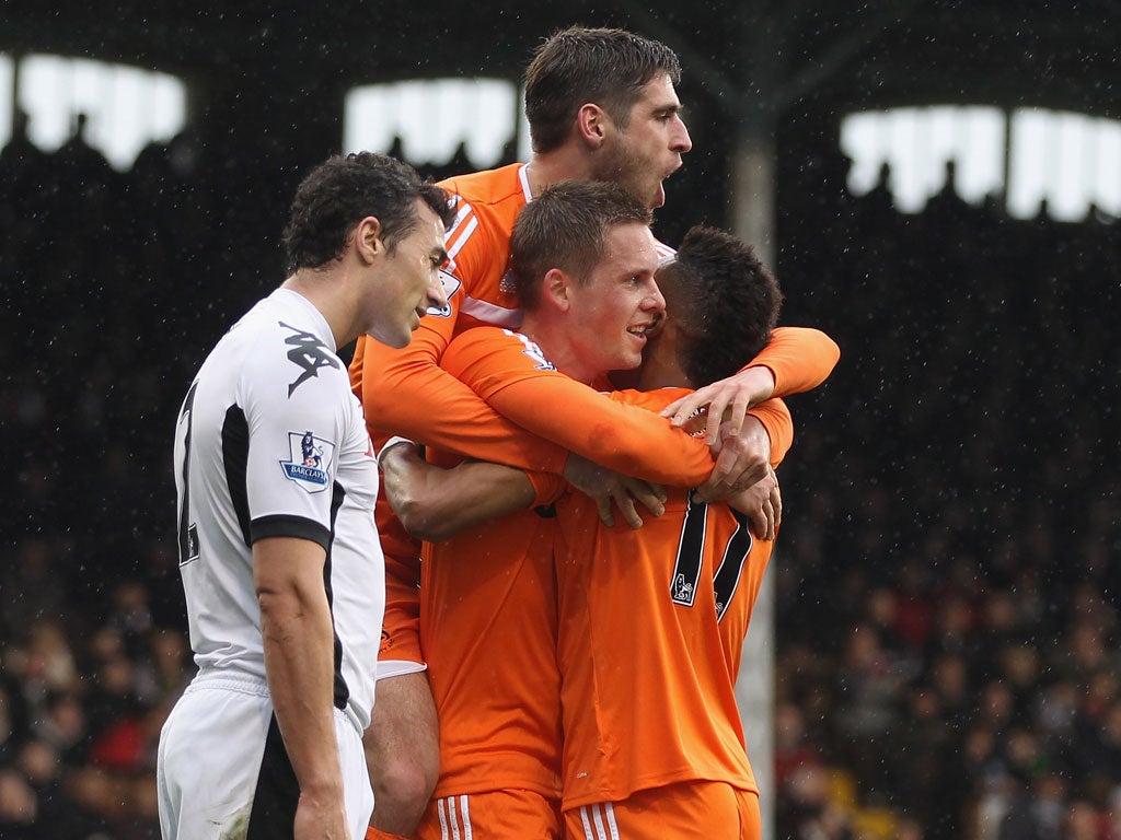 Flying Swans: Midfielder Gylfi Sigurdsson is swamped by Swansea team-mates after scoring the first of his two goals against Fulham at Craven Cottage