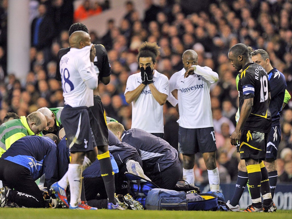 In shock: Players from Spurs and Bolton look on in disbelief as the seriousness of the situation begins to dawn