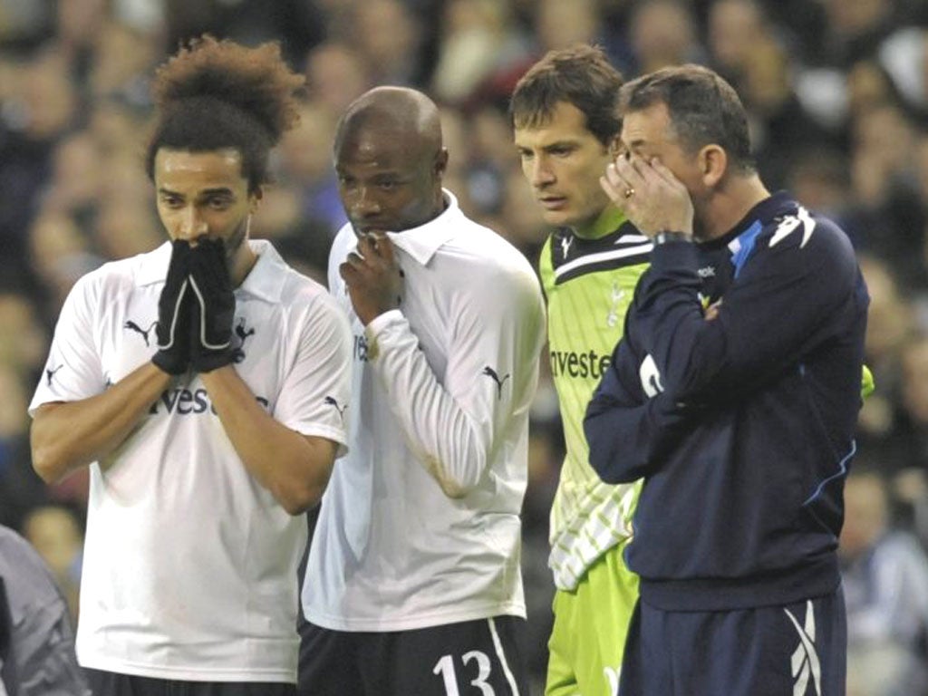 The Bolton manager, Owen Coyle (right), stands beside Spurs players Benoit Assou-Ekotto, William Gallas and Carlo Cudicini as Fabrice
Muamba is treated by medical staff at White Hart Lane