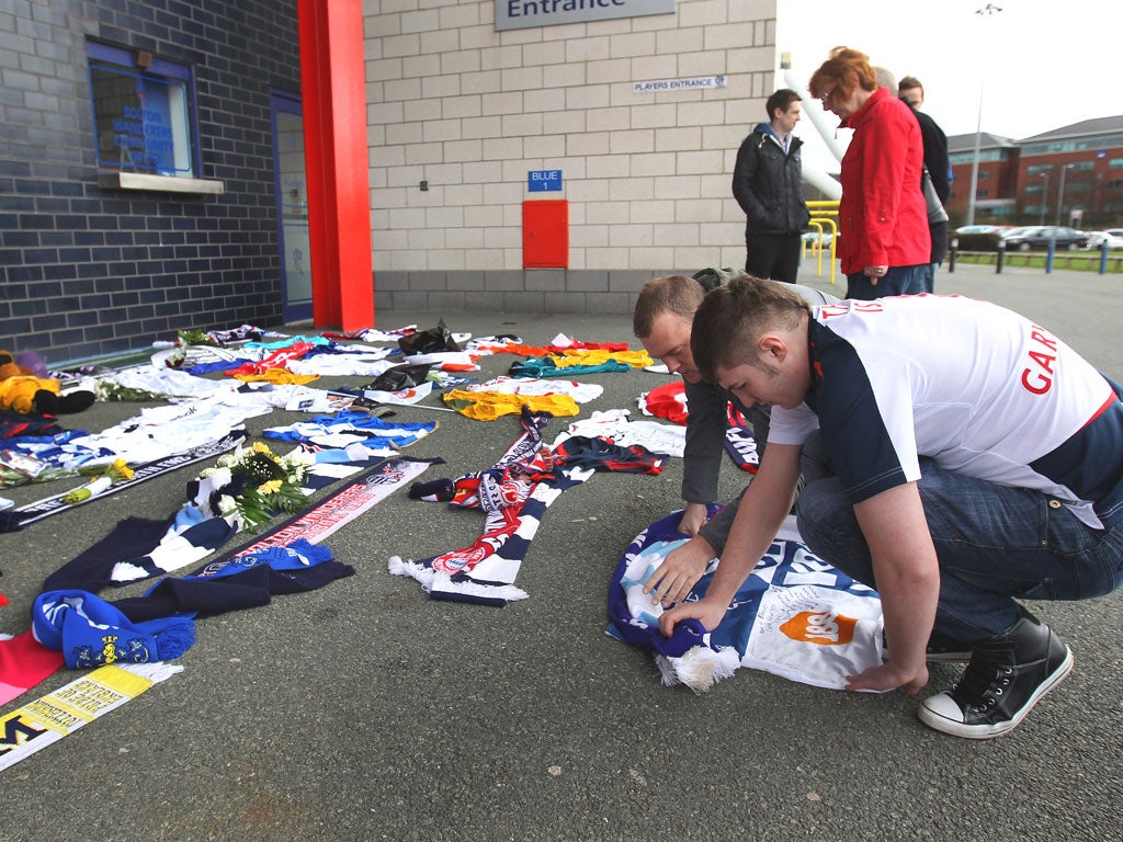 Fans lay a tribute to Fabrice Muamba outside the Reebok Stadium in Bolton yesterday