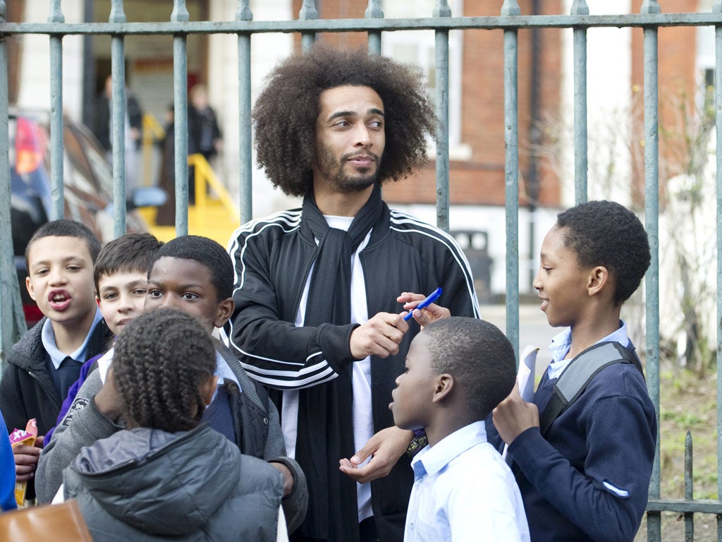 Tottenham Hotspur's French football player Assou Ekotto signs autographs for fans as he arrives at the London Chest Hospital earlier today
