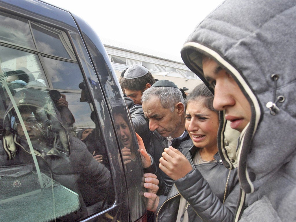 Mourners watch a hearse carrying the coffins of the three children slain at Ozar Hatorah school in Toulouse